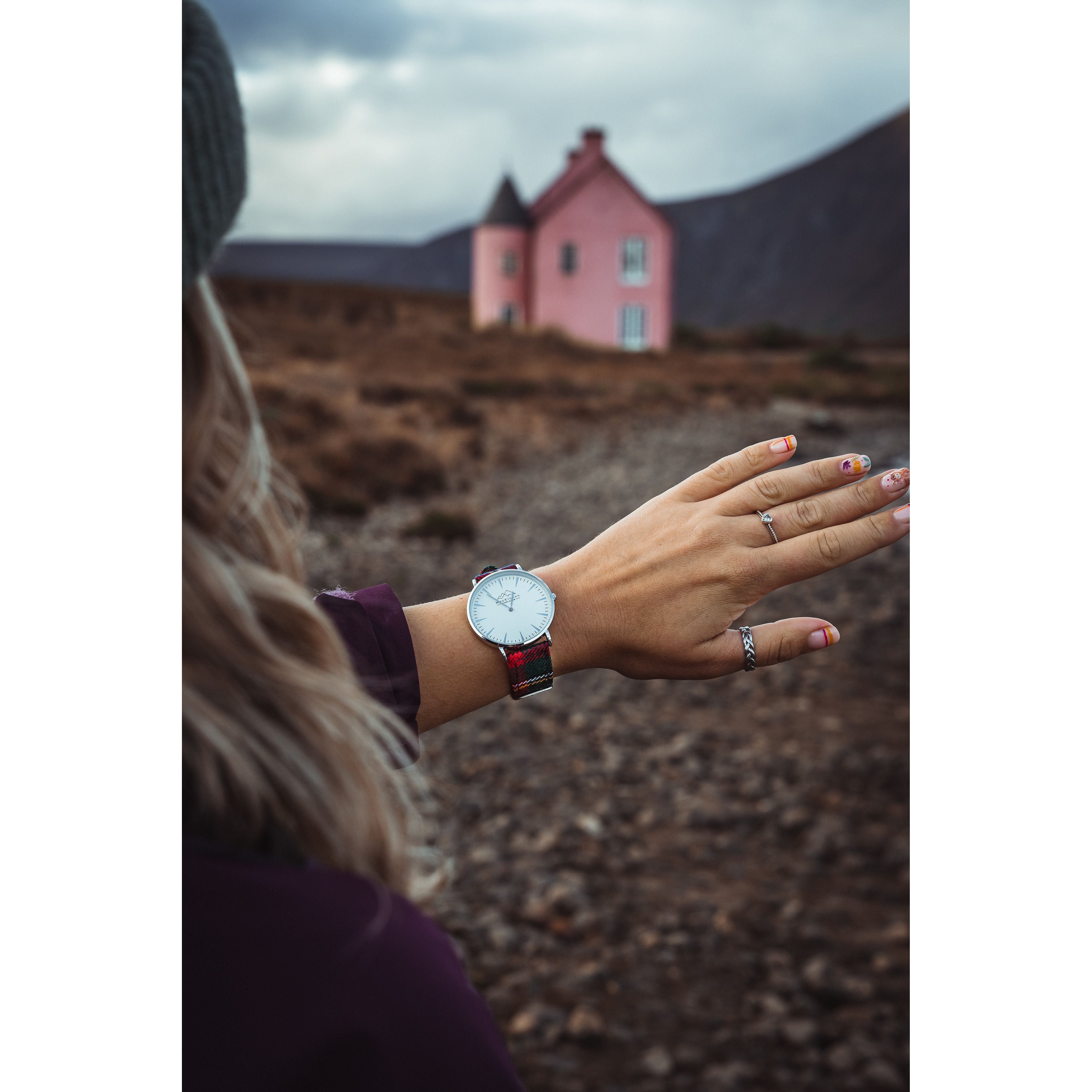 A woman checking the time on her custom tartan watch in Scotland