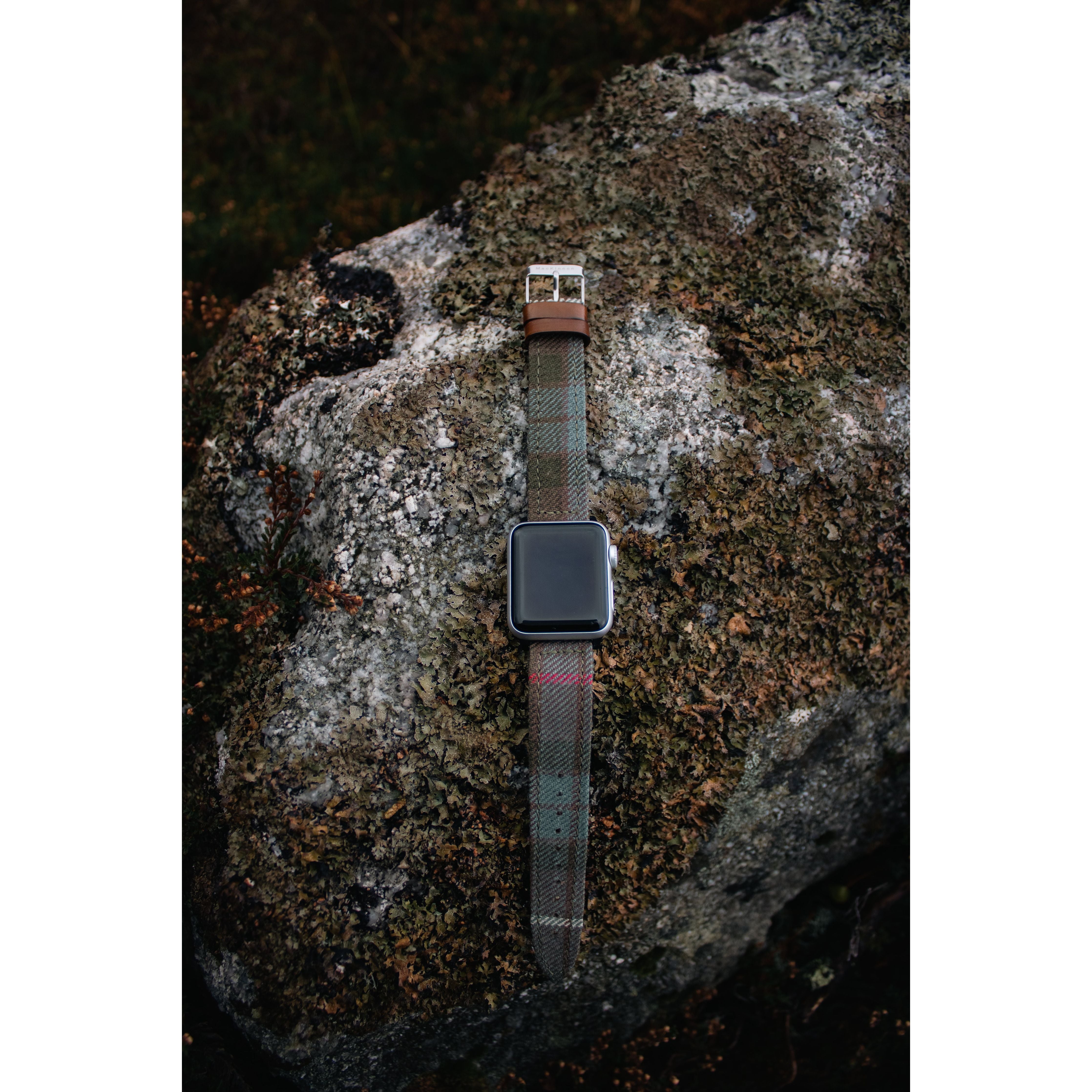 apple watch with tartan band on a boulder