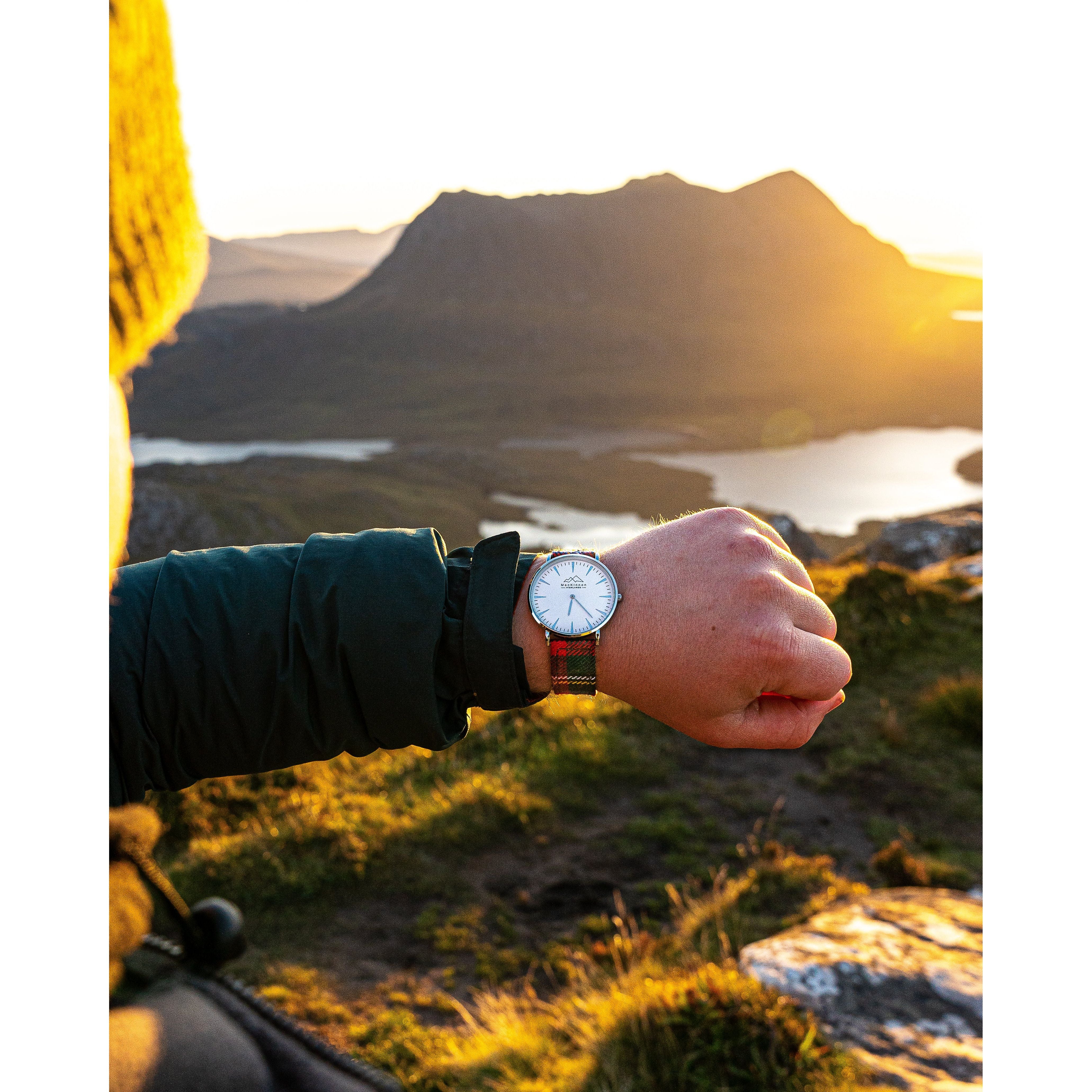 A man checking the time on his custom tartan watch in Scotland