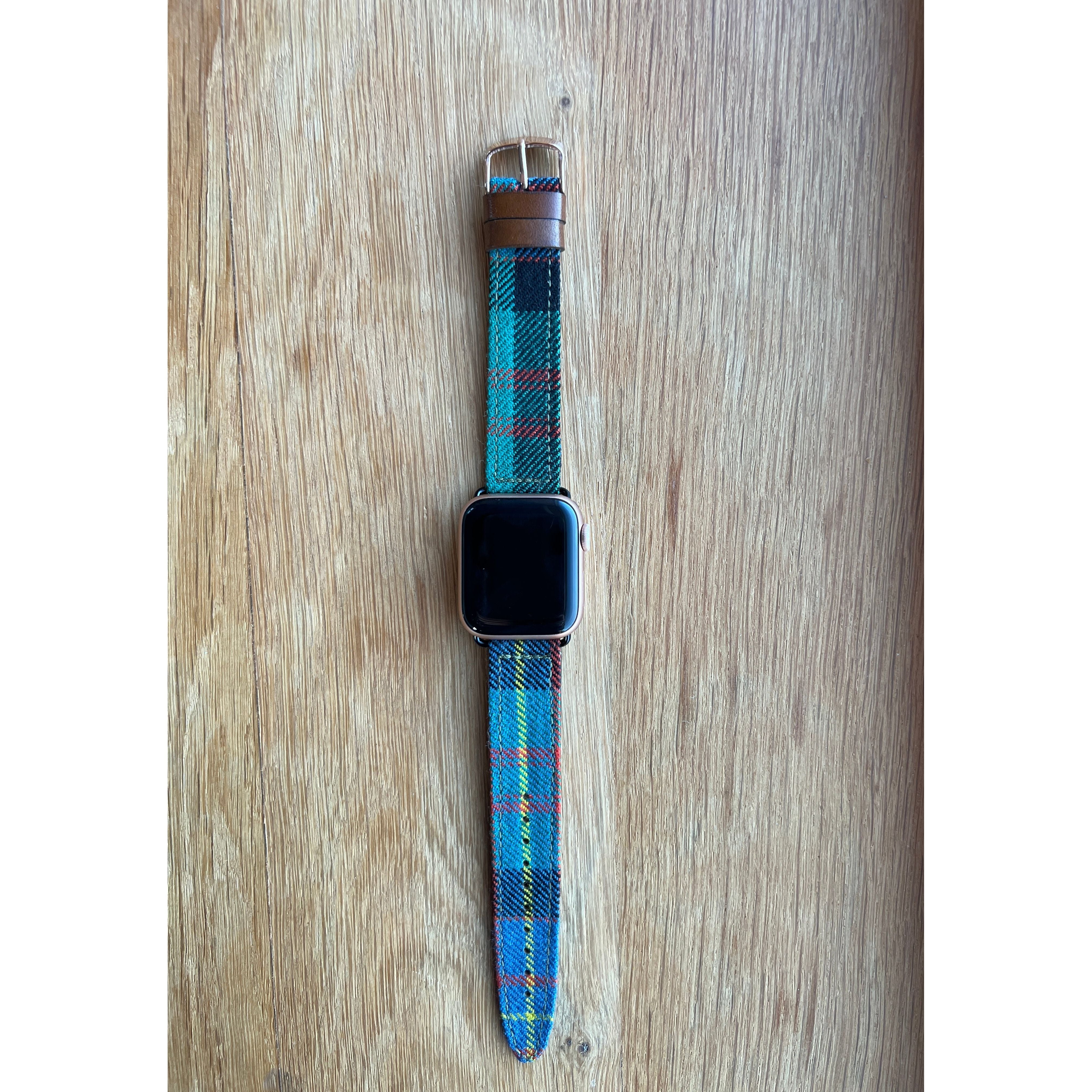 apple watch with tartan band sitting on a desk