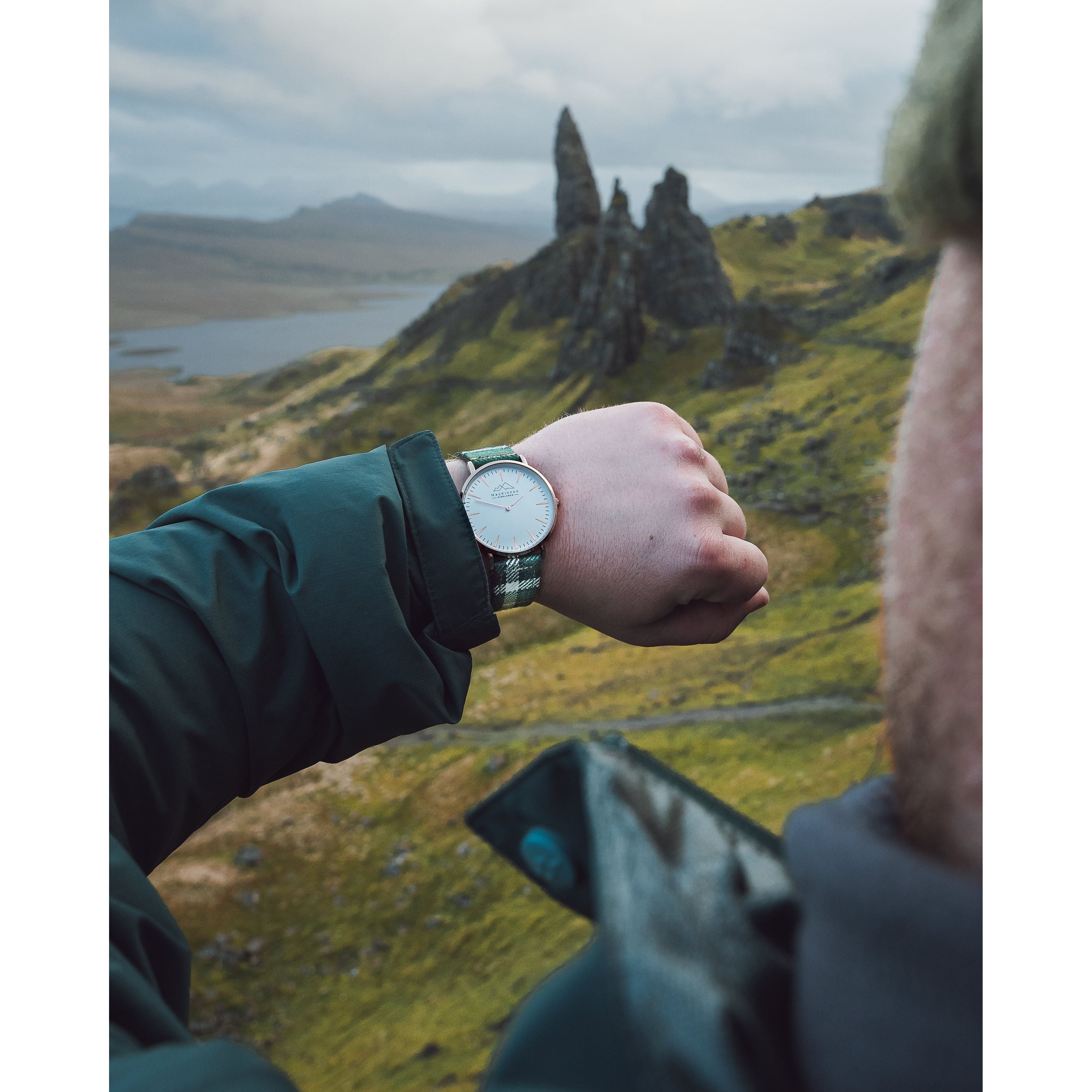 A man checking the time on his custom tartan watch in Scotland