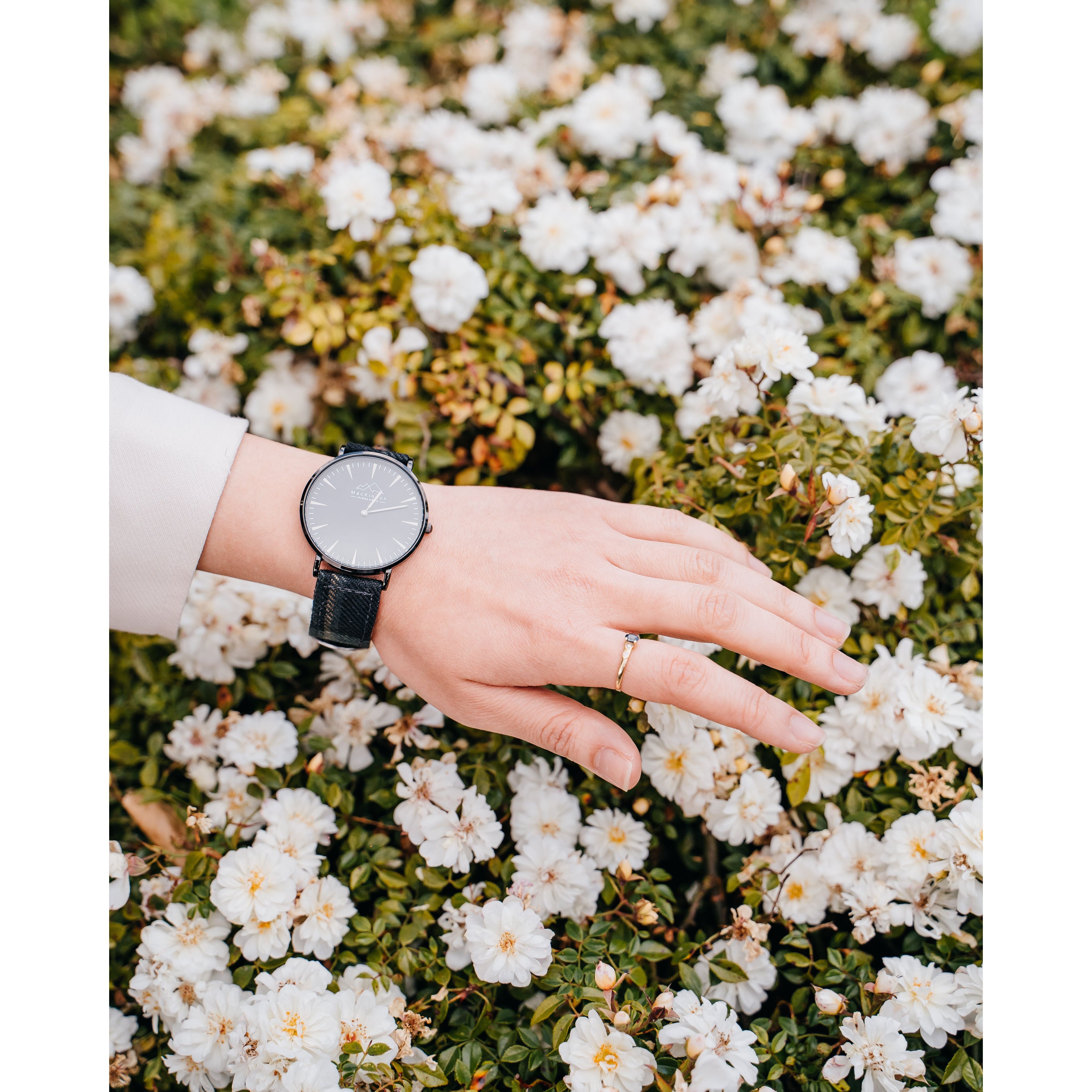 A woman's hand with a black tartan watch